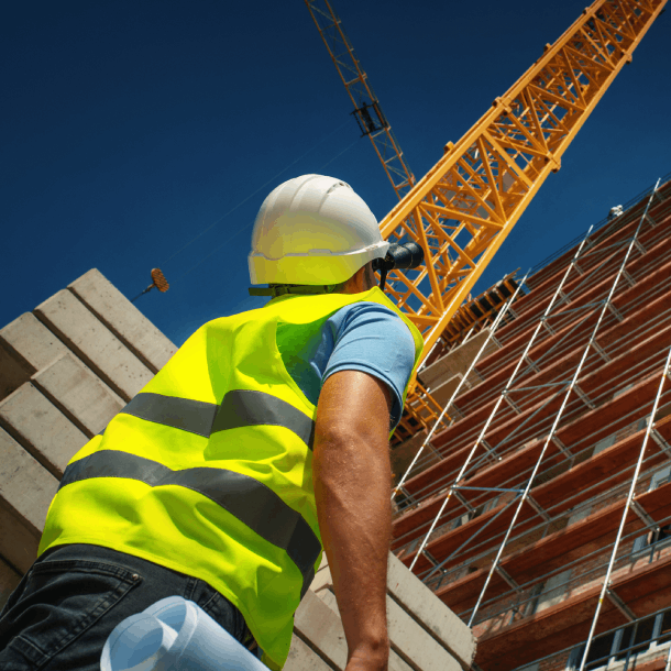 construction worker looking up at crane